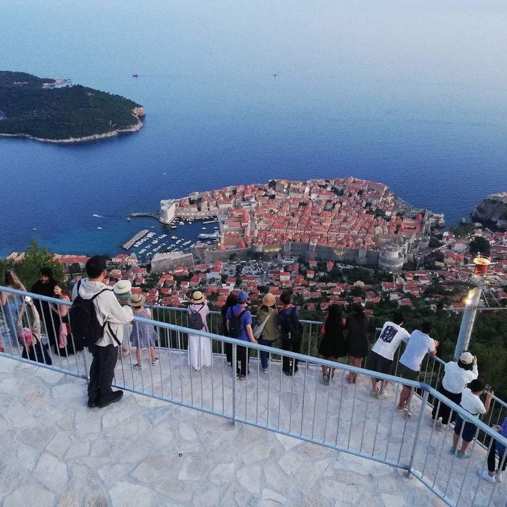 Visitors at the terrace railing looking out over the Old Town.