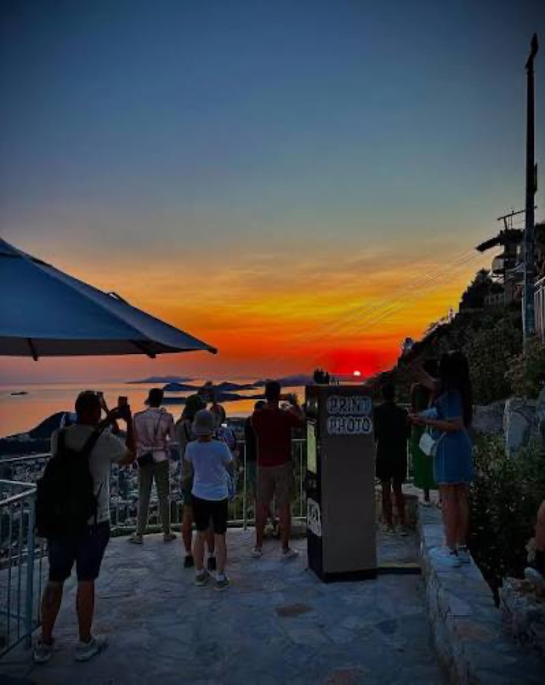 The terrace at sunset, silhouettes against the water.
