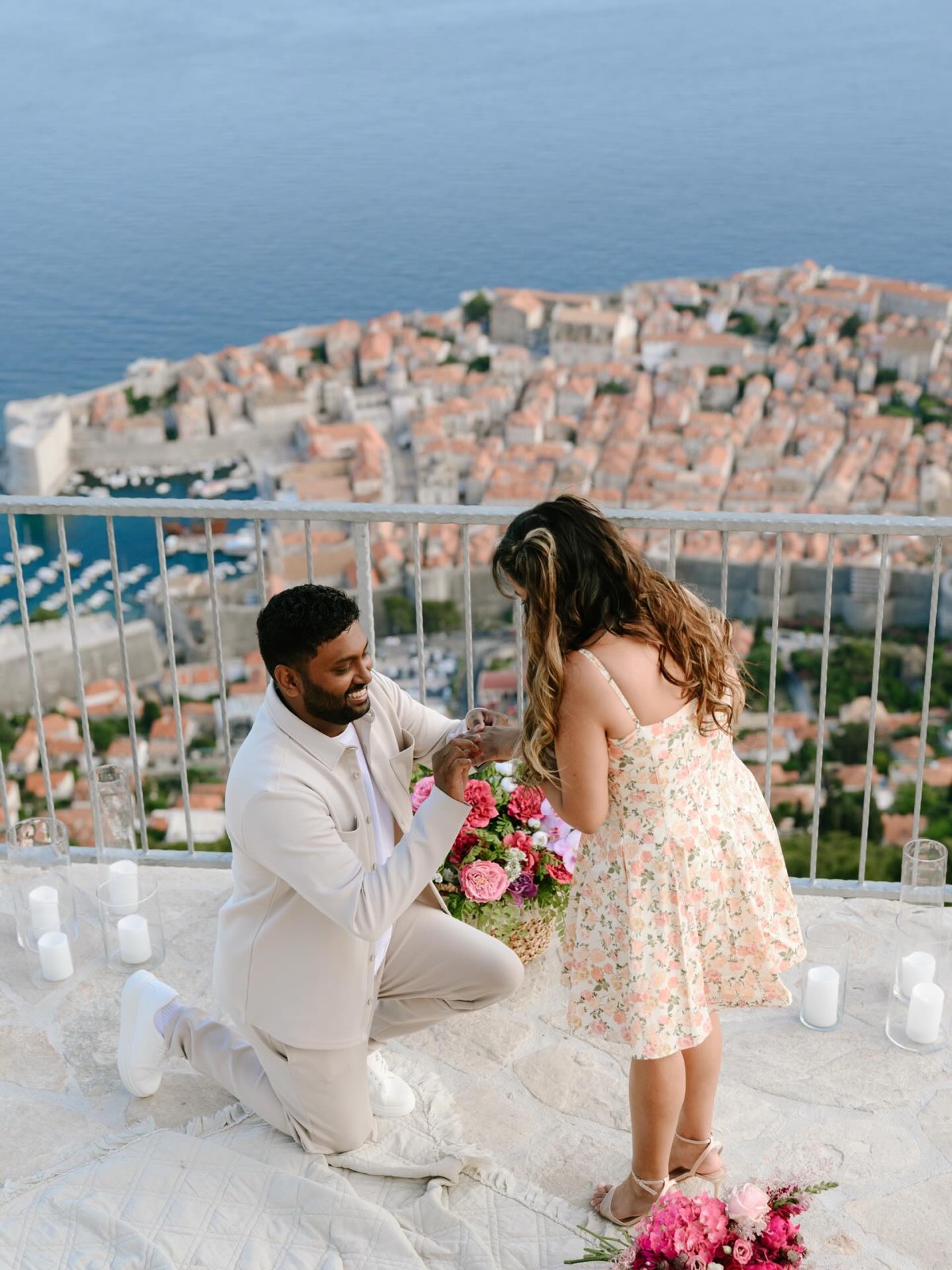 A proposal on the cliff terrace: candles and flowers set out, the Old Town far below.